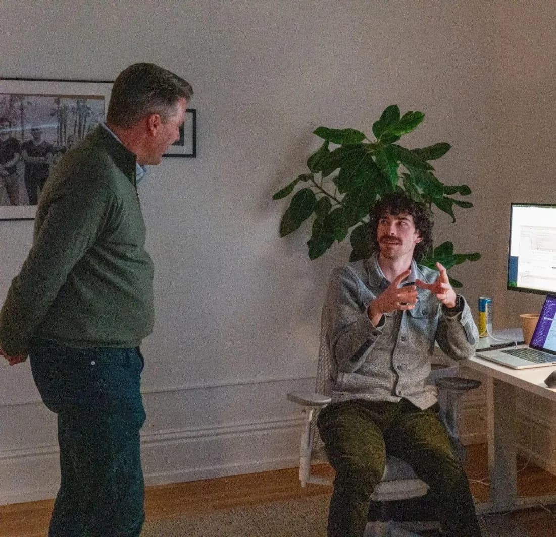 Two Adapt engineers talking through a problem at a desk